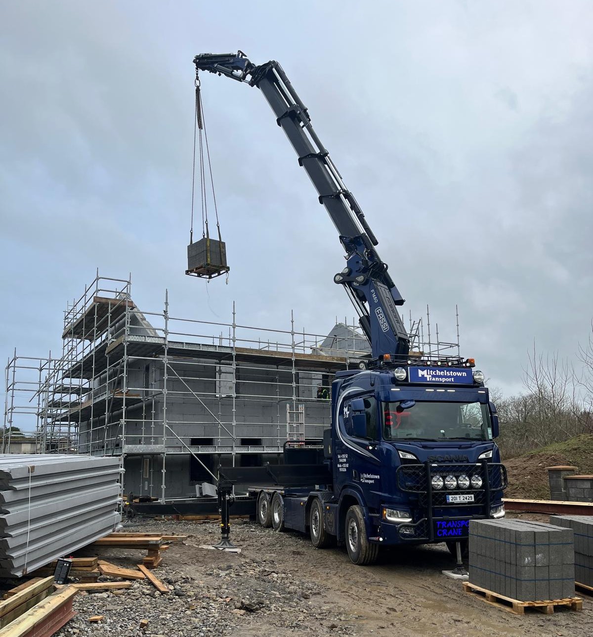 crane lifting concrete blocks into a building site.